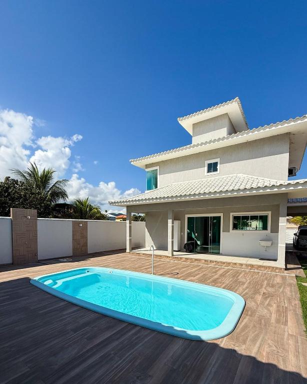 a swimming pool in front of a house at House in Jaconé in Maricá