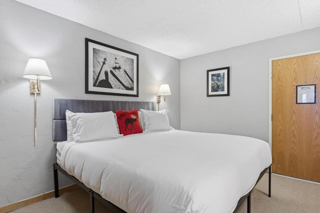 a bedroom with a large white bed and two lamps at Lift House Lodge, Downtown Vail Lionshead Village Studio Condo in Vail