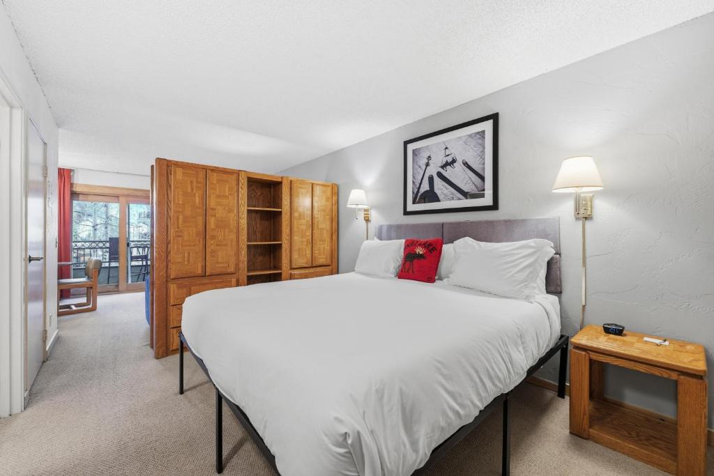 a bedroom with a large white bed and a table at Lift House Lodge, Vail Lionshead Studio Condo, Walk to Gondola in Vail