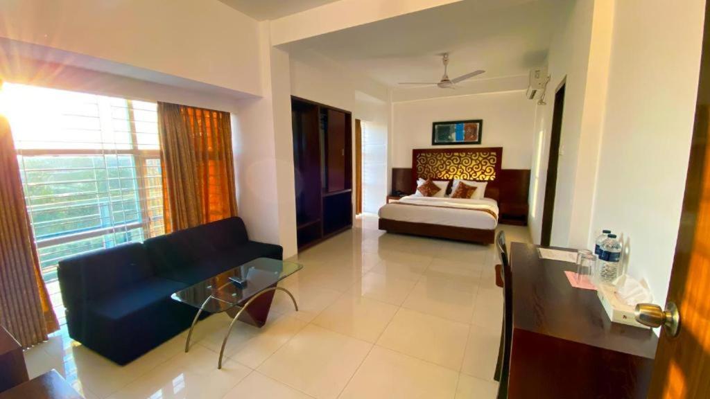 a bedroom with a bed and a couch in a room at Sylhet La Vista in Sylhet