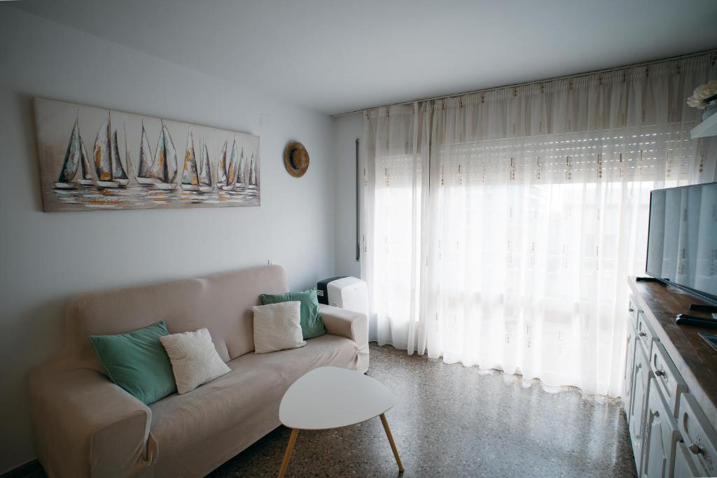 a living room with a couch and a tv at Apartamento Floral al centro de Palamós con Wi-Fi in Palamós