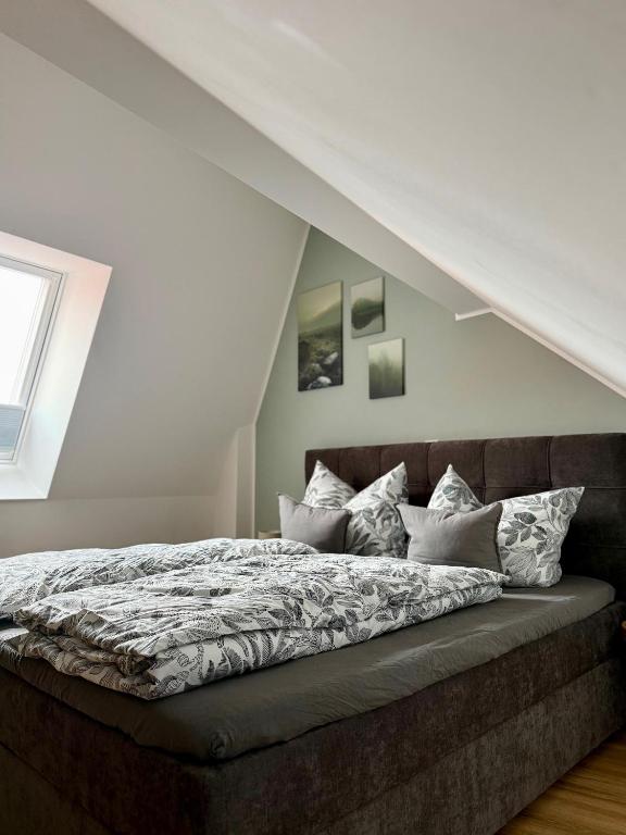 a bed in a room with a roof at Dachblick by Zirwick Apartment in Windischeschenbach