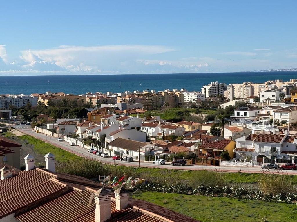 a view of a city with houses and the ocean at Casa Rebeca in Torre de Benagalbón