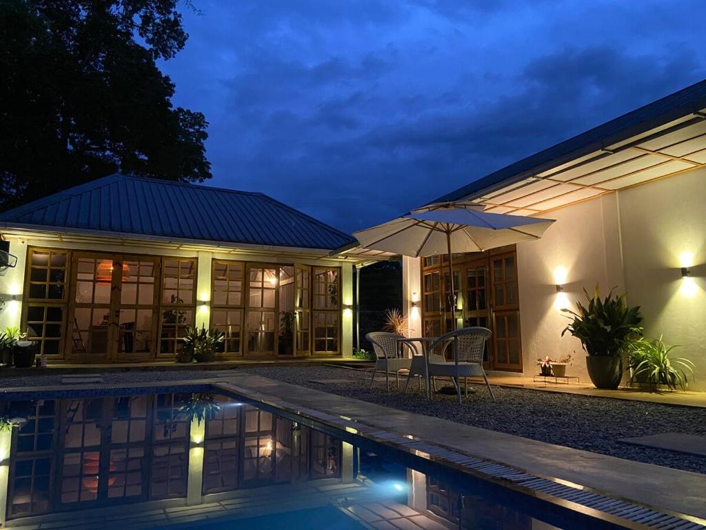a house with a swimming pool at night at TheMalkohaVilla in Umsning