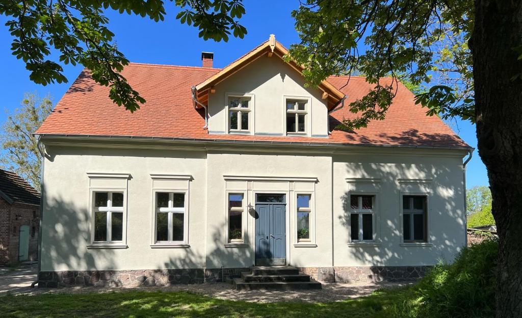 a white house with a red roof at Forsthaus Barsdorf in Fürstenberg