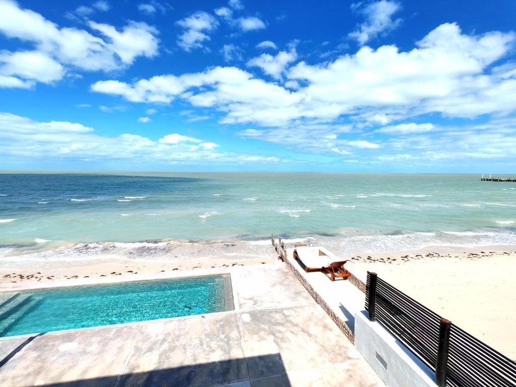 a swimming pool on the beach next to the ocean at On Beach Seaside Sunset Haven 2 - Epic Sea View in Chuburná