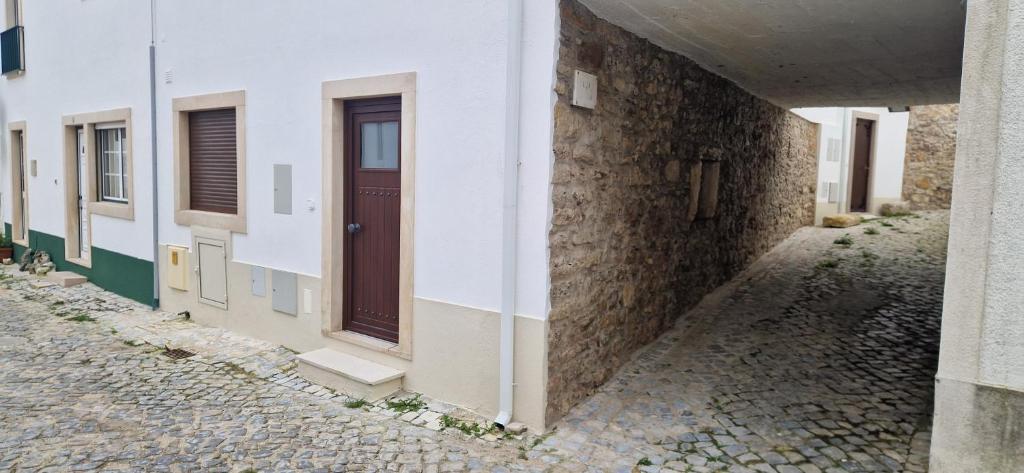 a building with a door on the side of a street at Casa do Arco in Aljubarrota