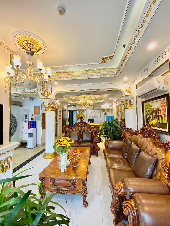 a living room with leather couches and a table at Nam Cường X Hotel in Hanoi