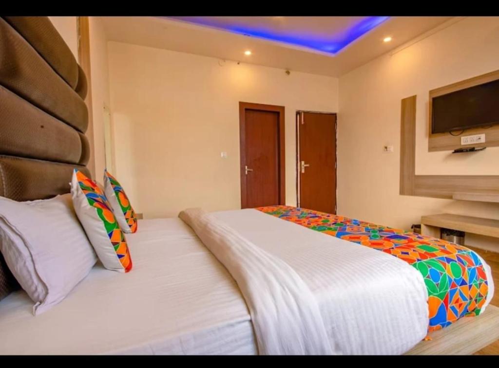 a bedroom with two beds and a tv on the wall at As Residency in Dehradun