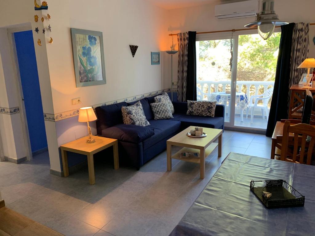 a living room with a blue couch and a table at Apartamentos, Edificio Pujolets Es Pujols-Playa in Es Pujols