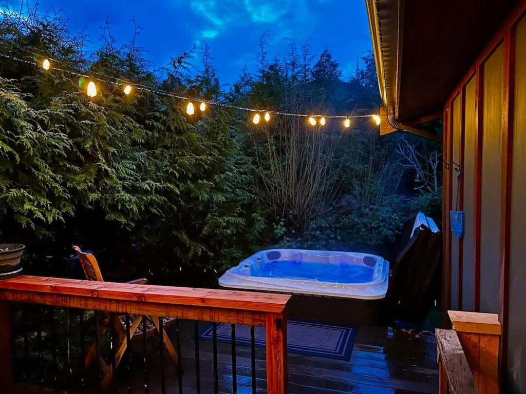 a jacuzzi tub sitting on a deck with lights at Hot Tub - Large Fully Enclosed deck - Pet Friendly in Port Renfrew