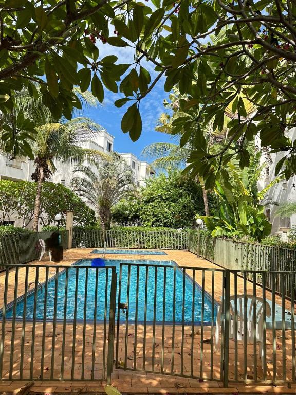 a swimming pool in front of a building at Apartamento próximo Santa Casa e ABQM in Araçatuba