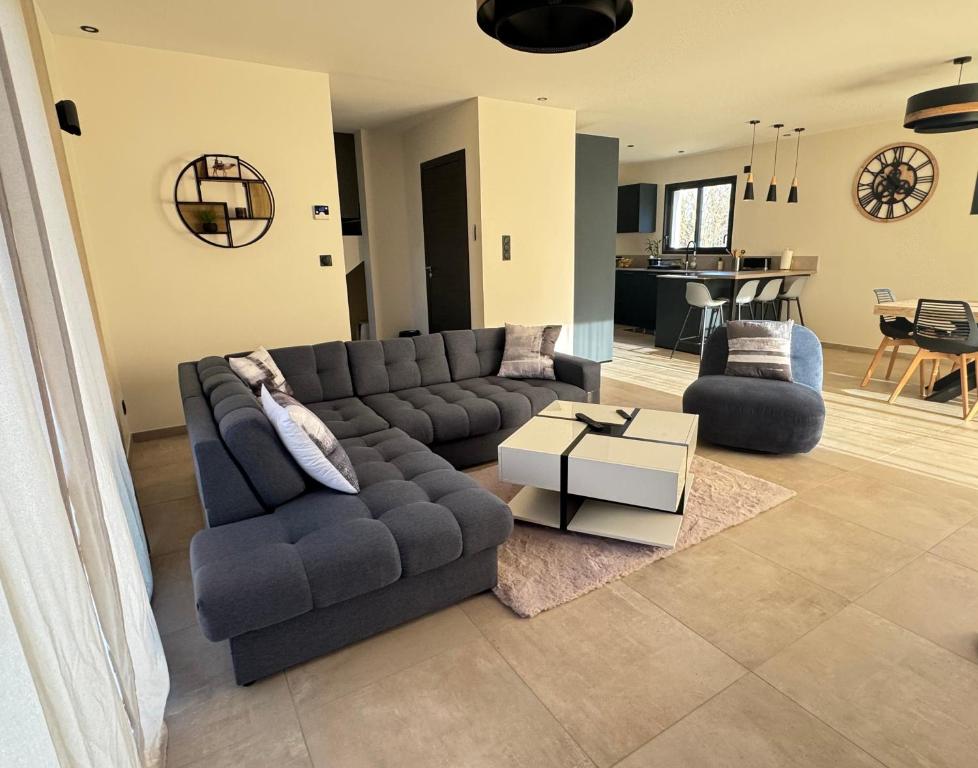 a living room with a couch and a table at Maison au calme à Pont-Évêque in Pont-Évêque