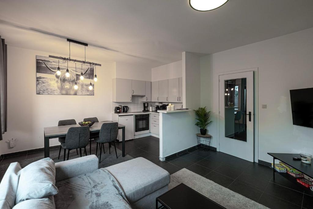 a living room and kitchen with a couch and a table at Appartement Wim in Blankenberge