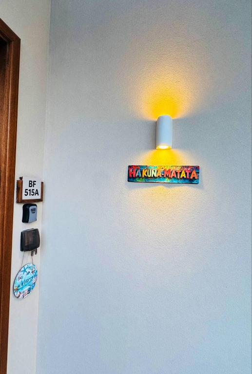a light on a wall with a sign on it at Hakuna Matata Villa - BF 515A in Muscat