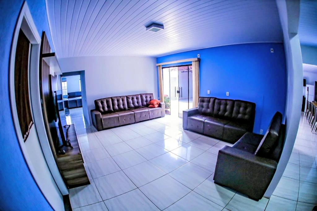 a living room with two leather couches and blue walls at Casa grande com piscina área gourmet in Cascavel