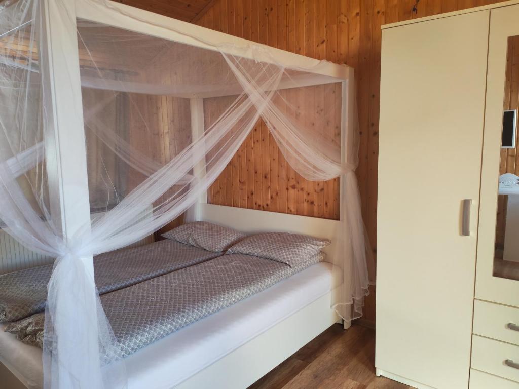 a bedroom with a canopy bed with mosquito nets at casa tip duplex in Zărneşti