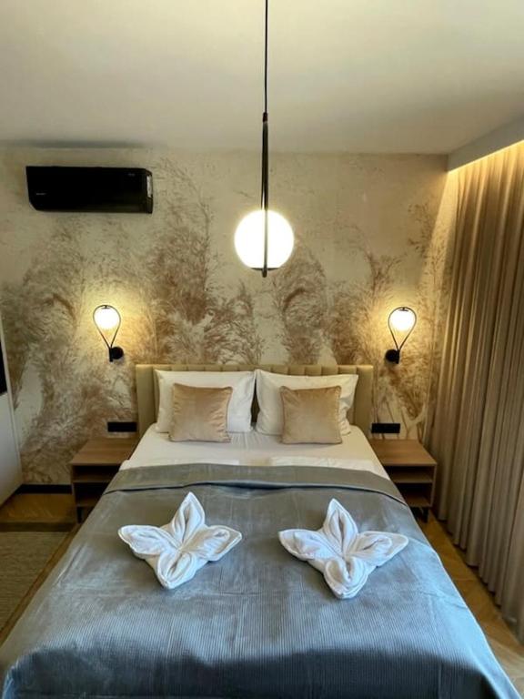 a bedroom with a bed with two white flowers on it at Apartamenty Skalny Loft in Karpacz