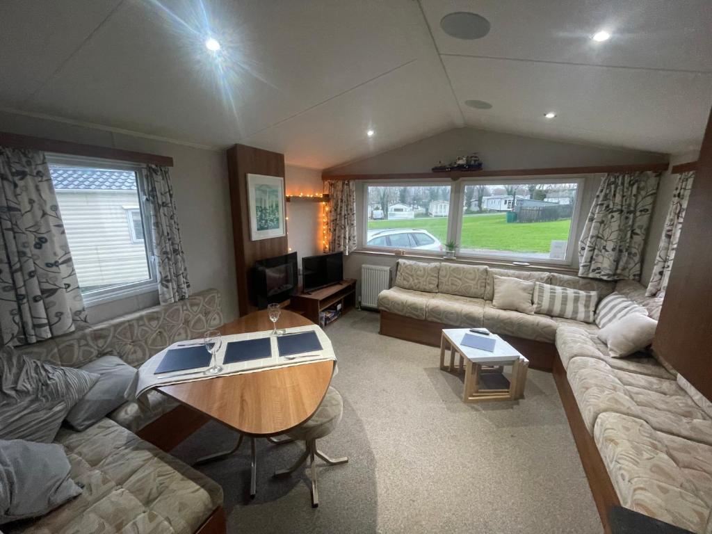 a living room with a couch and a table at 26 The Green Captains Cabin in Crantock