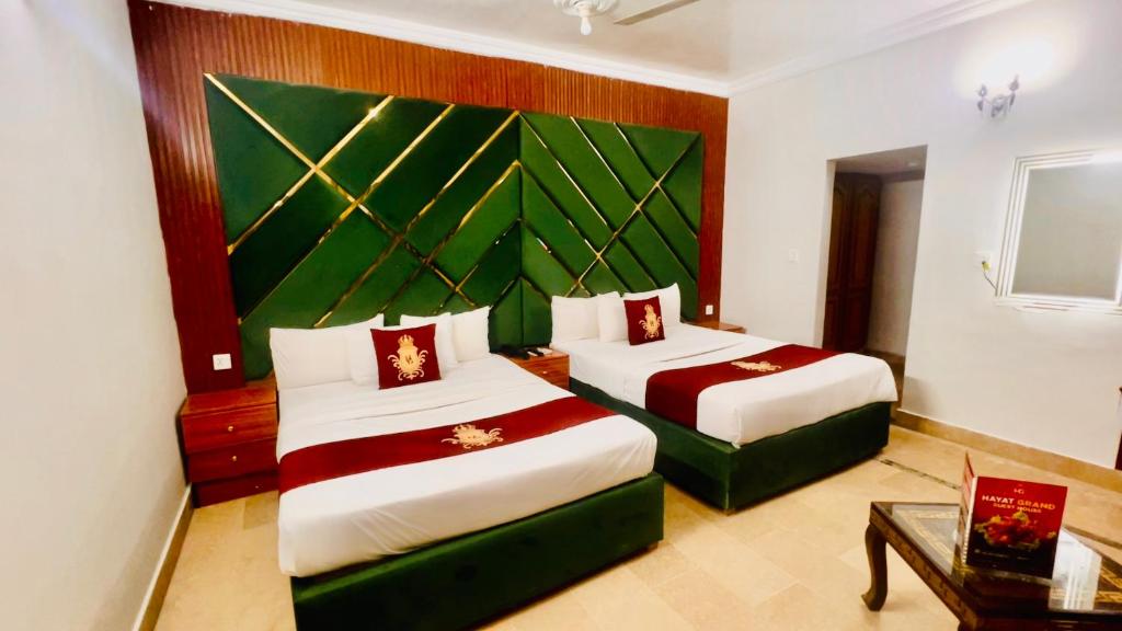 a hotel room with two beds and a table at Hazelton in Islamabad