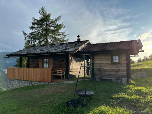 a small log cabin with a swing in front of it at Samalmglück in Maria Luggau