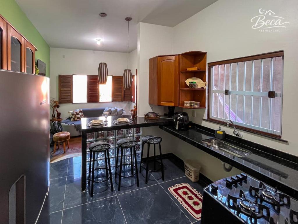 a kitchen with a counter and some bar stools at BECA Residencial in Canoa Quebrada