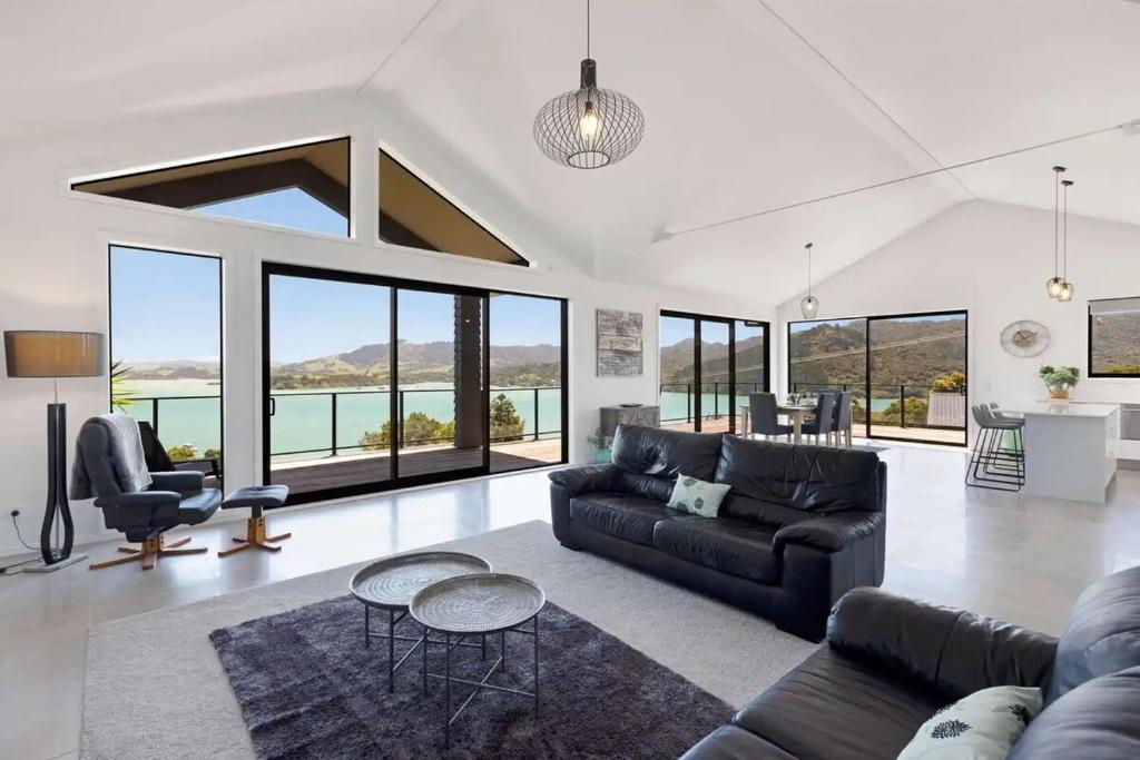 a living room with a couch and a table at Whangaroa Casa Roca House in Kaeo