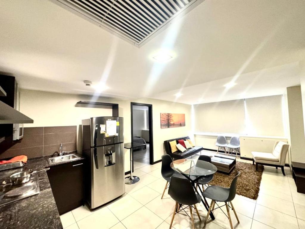 a kitchen and living room with a refrigerator and a table at Love Apartment in Guayaquil
