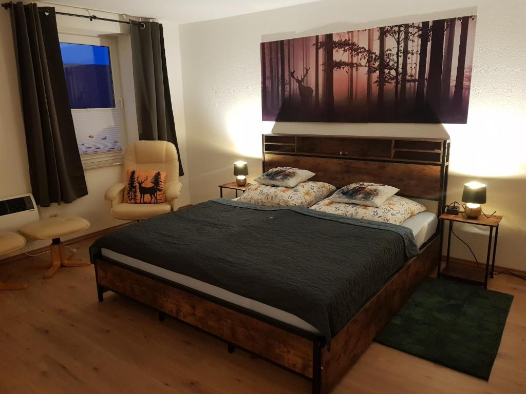 a bedroom with a large bed and a chair at Haus Flora in Hasselfelde