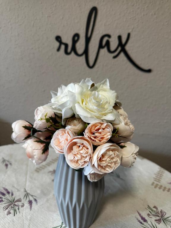 a vase filled with pink and white flowers with the word hello at RELAX13 Vendégház in Hévíz