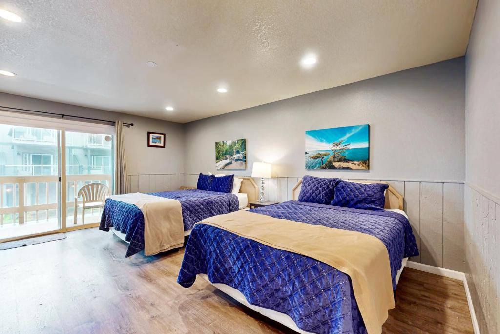 a bedroom with two beds and a window at Sea Treasures Inn #206 in Rockaway Beach