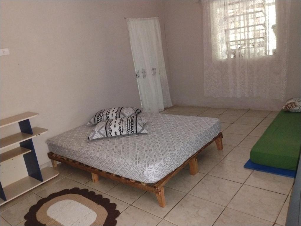 a bedroom with a bed with two pillows on it at Recanto Sebold in Guaratuba