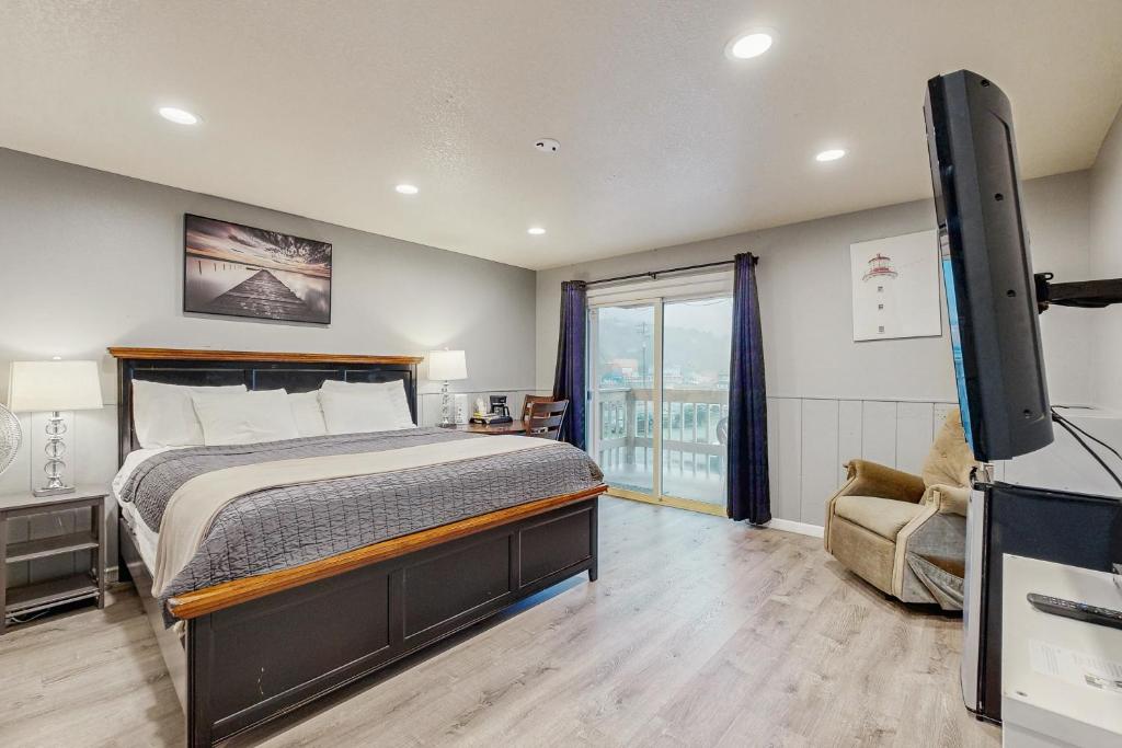a bedroom with a bed and a flat screen tv at Sea Treasures Inn #207 in Rockaway Beach