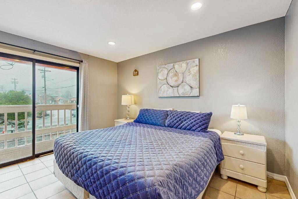 a bedroom with a bed and a balcony at Sea Treasures Inn #208 in Rockaway Beach