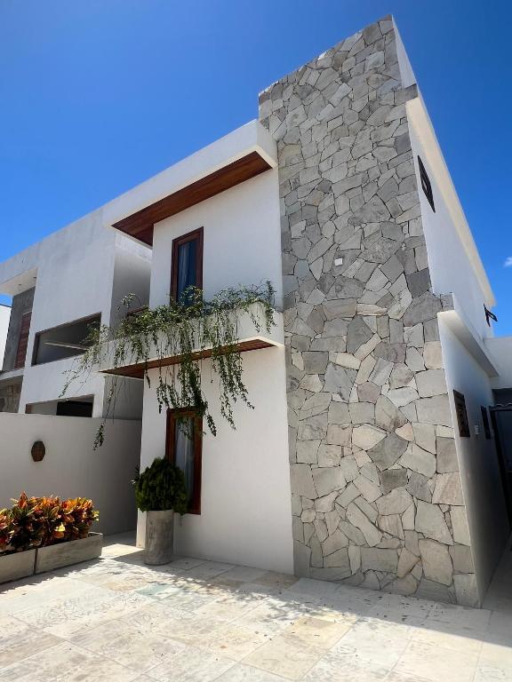 a white house with a stone wall at Sunny Kite House Prea in Prea