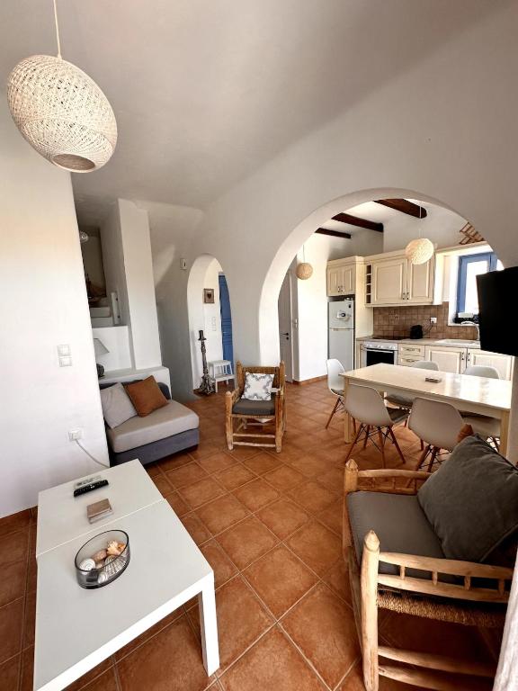 a living room with a table and a kitchen at Sea View Cycladic Home in Santa Maria