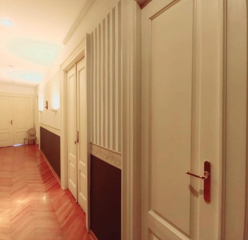 an empty hallway with a white door and a wooden floor at VelaMar in Trieste