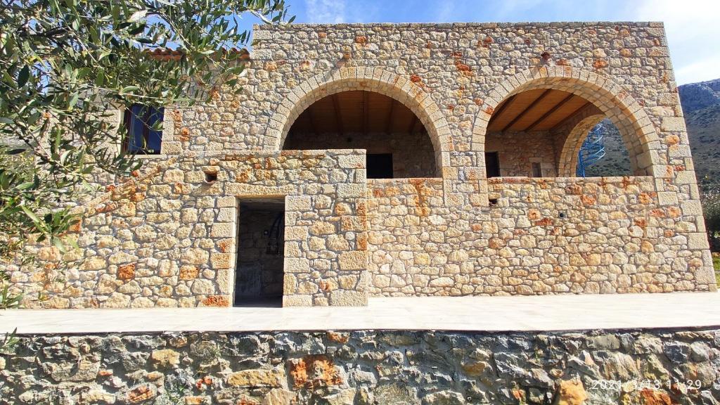 a stone building with two arches on it at Villa Seaview in Oitylo