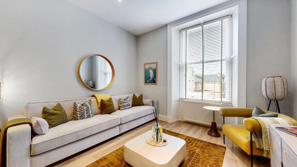 a living room with a couch and a mirror at The Sauchie in Glasgow