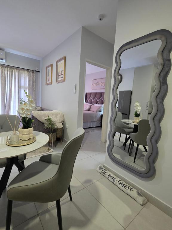 a living room with a table and a mirror at Habitat Kappa Alexio in Gaborone