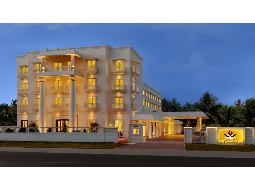 un grand bâtiment blanc éclairé dans l'établissement Daiwik Hotels Rameswaram, à Rameswaram