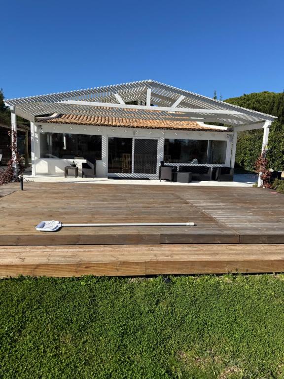 a house with a large wooden deck in front of it at Vila Brisa do Mar in Comporta