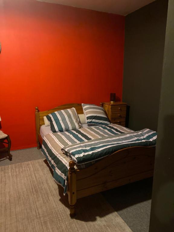 ein Bett in einem Schlafzimmer mit einer orangefarbenen Wand in der Unterkunft Suite Étoile in Villebon-sur-Yvette