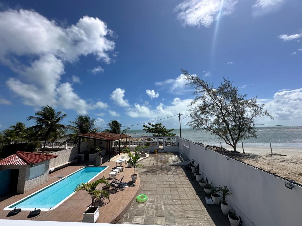 a view of a swimming pool and the beach at Casa Beira Mar lha de Itamaracá in Itamaracá