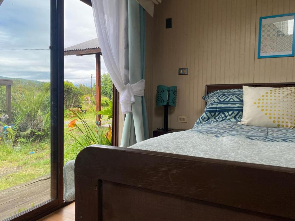 a bedroom with a bed and a large window at La Casona del Trancura in Pucón