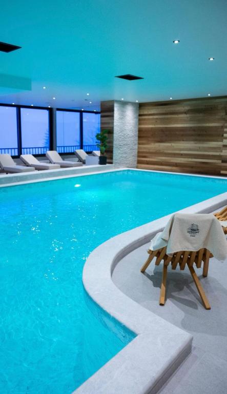 a swimming pool with a lounge chair in a building at Prestige Lux Andan - Apart hotel Horizont Jahorina in Jahorina
