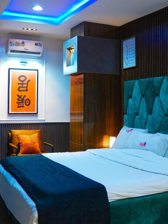 a bedroom with a large bed with a blue ceiling at SUITE De PARIS in Abuja