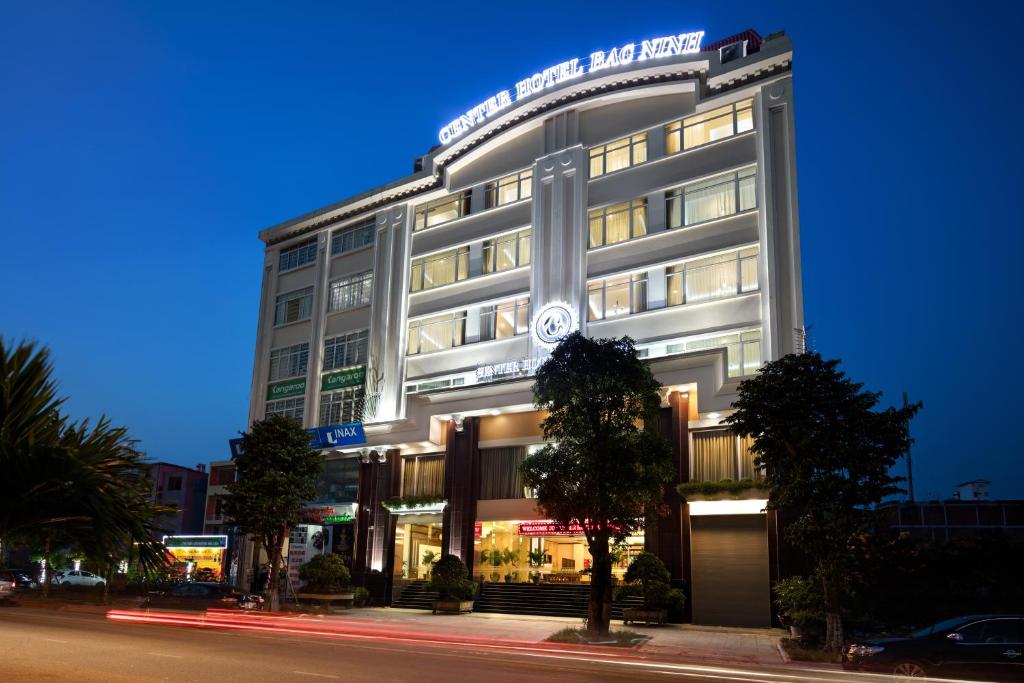 a large white building on a city street at night at Center Hotel Bac Ninh in Bắc Ninh