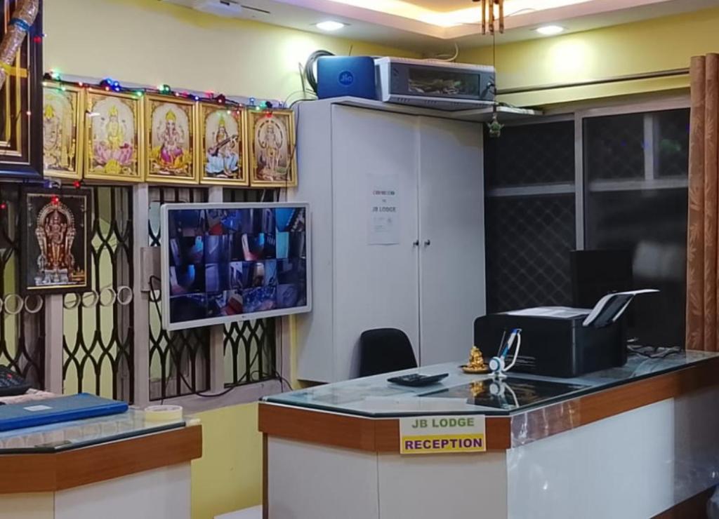 an office with a desk with a computer on a counter at JB lodge in Chidambaram