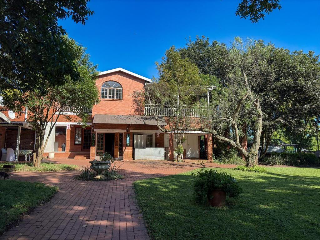 a brick house with a balcony on top of it at Aintree Lodge in Pietermaritzburg